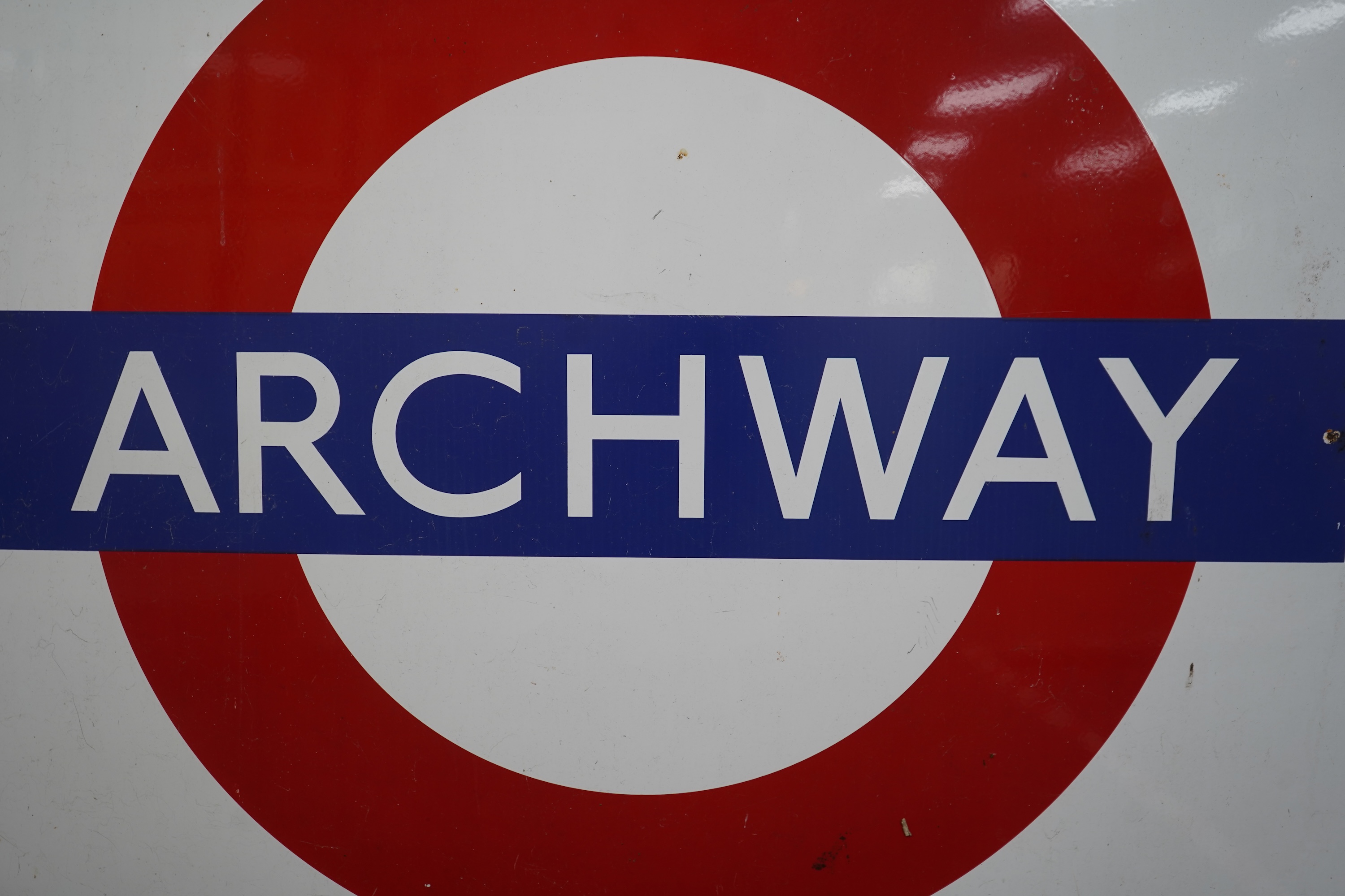 A 1950s/60s London Underground enamel bullseye station sign for Archway, 152.5cm wide, 122cm high, with plied manufacturers sticker for ‘Burnham Signs’ to the reverse